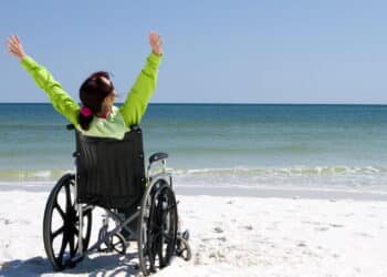 Imagem de mulher cadeirante na praia - Créditos: depositphotos.com / sframe