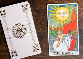 Carta de Tarô do Sol do baralho Rider Waite sobre fundo de madeira