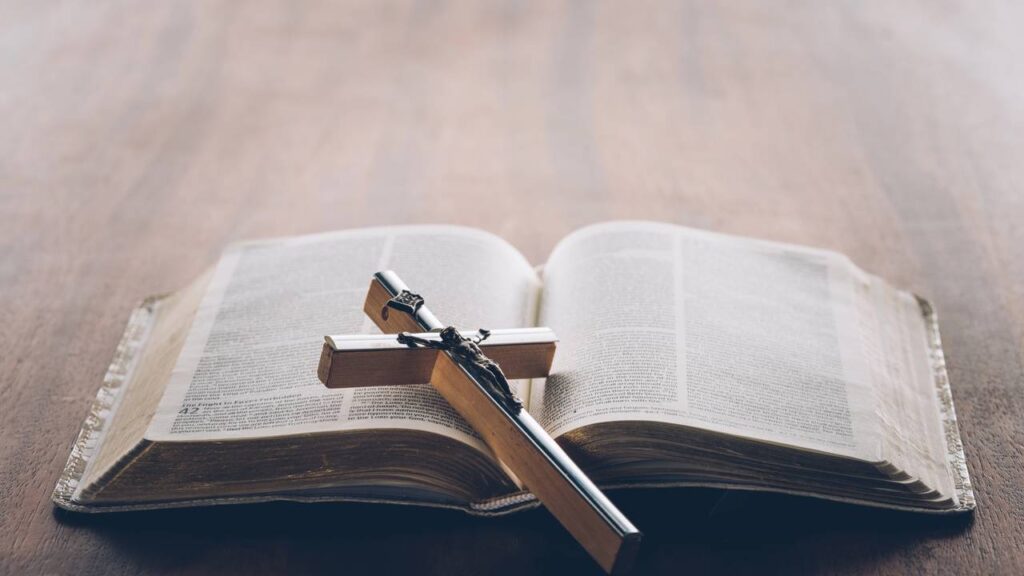 christian cross on open holy bible