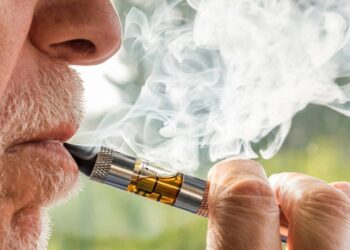 Homem idoso adulto fumando um cigarro eletrônico Créditos: depositphotos.com / elesi