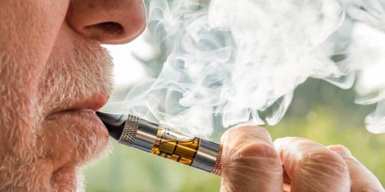 Homem idoso adulto fumando um cigarro eletrônico Créditos: depositphotos.com / elesi