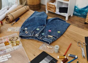 Reaproveitamento criativo de roupas em uma mesa de madeira desorganizada com um conceito ecológico.