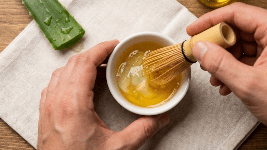 Mãos preparando a mistura de babosa e rícino em um bowl cerâmico