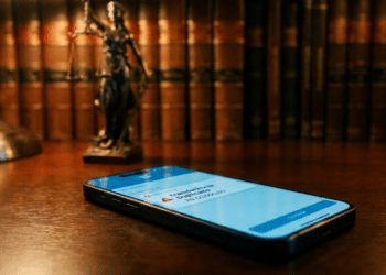 Celular exibindo transferência duplicada em escritório jurídico