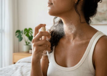 Detalhe do spray de perfume sendo aplicado na lateral do pescoço