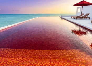 Piscina rubi contrasta com mar azul ao pôr do sol