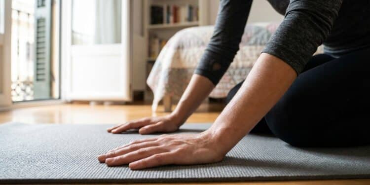 Mulher realizando exercício de prancha no chão do quarto