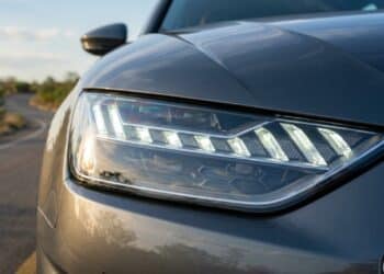 Farol com luz DRL ativa em rodovia ensolarada
