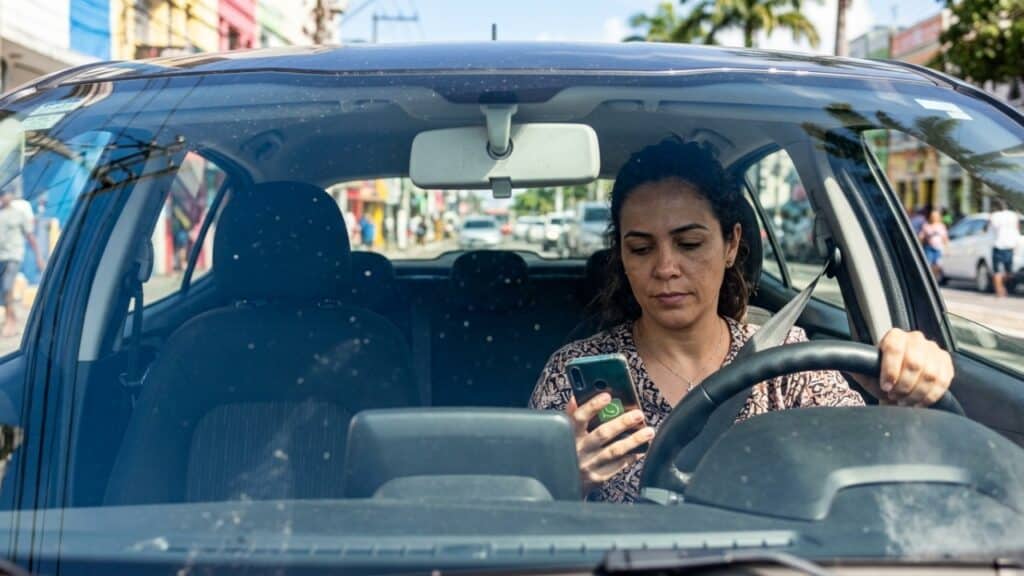 Mexendo no celular durante o trânsito