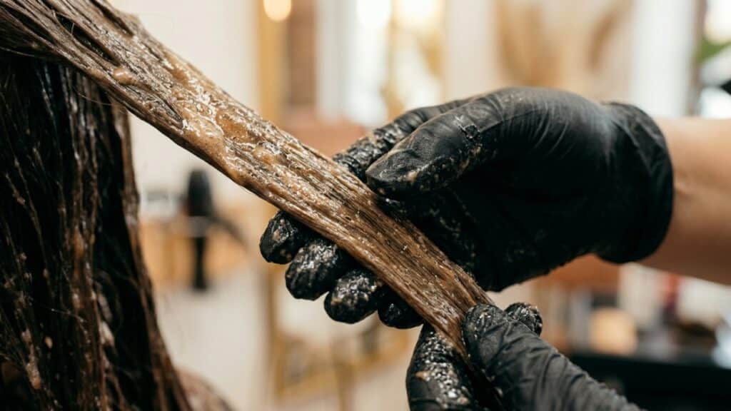 Aplicação de tintura cremosa em mechas de cabelo saudável