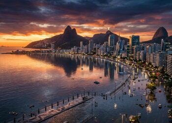 Cidade litorânea inspirada no Rio de Janeiro aparece alagada ao entardecer, com prédios, mar, montanhas e vias tomadas pela água.