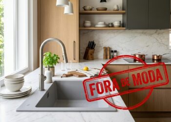 Cozinha moderna com pia sobre bancada clara aparece com carimbo vermelho com a frase “Fora de moda”.