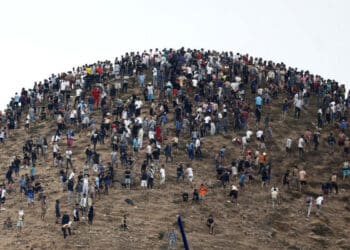 Pessoas se reúnem no topo de uma colina próxima ao local de confrontos perto de Fnideq, na fronteira entre o Marrocos e a Espanha (ABDEL MAJID BZIOUAT/AFP)
