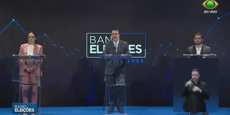 À esquerda, a candidata ao governo Juliana Brizola (PDT-RS); à direita, o candidato Gabriel Souza (MDB); no centro, o apresentador e jornalista Oziris Marins  • Youtube/Band RS