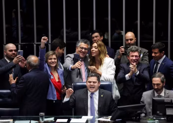 Colegas parlamentares comemoram enquanto o presidente do Senado Federal, Davi Alcolumbre, anuncia o resultado da votação a favor de uma emenda constitucional que reduz a jornada de trabalho no Brasil de seis para cinco dias, em Brasília, Brasil, 14 de outubro de 2026 — Foto: REUTERS/Adriano Machado