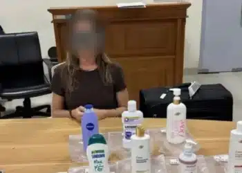 Brasileira presa em Bali aparece ao lado dos frascos apreendidos pela polícia local; autoridades encontraram cocaína líquida diluída em produtos de higiene pessoal
| Foto: Divulgação/ Polícia Nacional da Indonésia